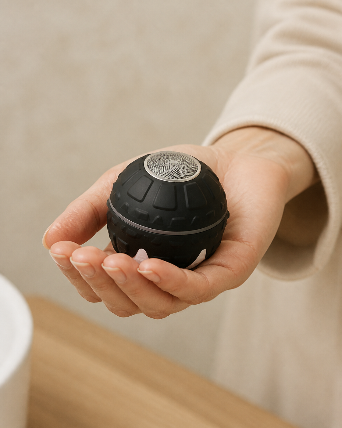 The black ORBÉ body trimmer resting naturally in a woman's palm